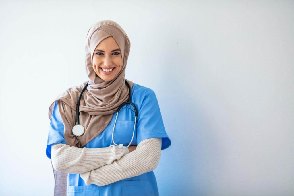 A woman wearing a headscarf smiles at the camera.